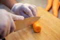 Close up shot of a chef chopping carrots on a wooden chopping board. Royalty Free Stock Photo