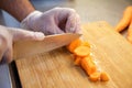 Close up shot of a chef chopping carrots on a wooden chopping board. Royalty Free Stock Photo