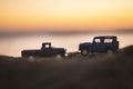 Close up shot of a Chevrolet 3100 pickup truck and a Blue colored land rover Suv vehicle on sand and on sunset Royalty Free Stock Photo