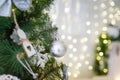 Close up shot of Christmas tree branch with bauble and wooden toys. Beautiful garland lights boke on background, copy space Royalty Free Stock Photo