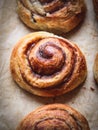 Close up of a cinnamon bun on a baking paper shot from above