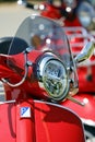 Vertical closeup of a Red Vespa motor-scooter