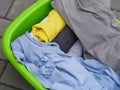 A close-up shot of clean dried clothes laying in a green laundry basket Royalty Free Stock Photo