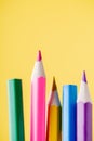 Close-up shot of colored pencils standing on the yellow background. Royalty Free Stock Photo