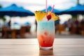 A close-up shot of a colorful tropical cocktail on a beachside bar