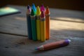 A close-up shot of colourful crayons on a wooden table with paper Royalty Free Stock Photo