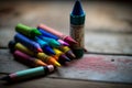 A close-up shot of colourful crayons on a wooden table with paper Royalty Free Stock Photo