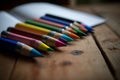 A close-up shot of colourful crayons on a wooden table with paper Royalty Free Stock Photo