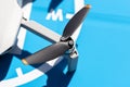 A close-up shot of the complex propellers and brushless motor of a drone against the backdrop of a blue landing pad. Royalty Free Stock Photo