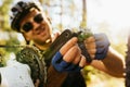 Close up shot of concentrated and smiling young rider in helmet, glasses and gloves sitting in front of his bicycle, repair pedal Royalty Free Stock Photo