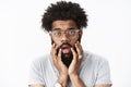 Close-up shot of concerned and worried adult african american bearded guy with afro hairstyle open mouth shook and Royalty Free Stock Photo