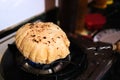 Close up shot of cooking a roti or chappati being roasted puffed and swollen on a blue gas flame in the kitchen
