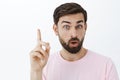 Close-up shot of creative and excited handsome male with beard and short dark hair open mouth raising eyebrow showing