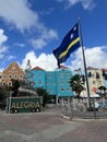 Close up shot of Curacao flag in Downtown Willemsted historic city street colourful buildings with pastel-colored