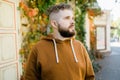 Close up shot of curly European male with beard wears switshot outdoors. Handsome man with crisp light hair.