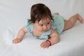 Close-up shot of a cute baby toddler on a white fabr Royalty Free Stock Photo