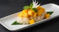 Delicious mango sticky rice dessert with mint and white flower garnish on a white plate sweet Royalty Free Stock Photo