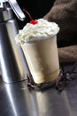 Close up shot of delicious creamy chocolate cold milkshake with whipped cream on top