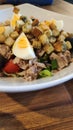 Close-up shot of delicious tuna salad served with fresh vegetable, tomatoe, olive and boiled eggs Royalty Free Stock Photo