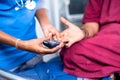 Close up shot of doctor checking sugar or diabetes level of sick woman on hospital bed - concept of monitoring health