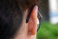 Close-up shot of the ear of a girl wearing glasses seen from behind.