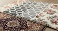 A close-up view of various carpet samples showcasing diverse patterns like floral, geometric, and traditional designs. Royalty Free Stock Photo