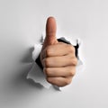 Thumbs Up Through Torn Paper Royalty Free Stock Photo