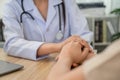 Close-up shot of female doctor holding hands giving advice and encouragement to female patient at clinic office in hospital Royalty Free Stock Photo