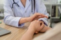 Close-up shot of female doctor holding hands giving advice and encouragement to female patient at clinic office in hospital Royalty Free Stock Photo