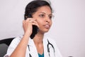 Close up shot of Female doctor talking on mobile phone in her office - concept of telehealth, telehealth service during Royalty Free Stock Photo