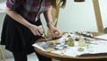 Close-up shot of female hands squeezing out a tube of paint onto the palette