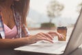 Close up shot of female hands typing on a laptop keyboard. Young woman studying and working in the park