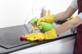 Close up shot of female hands holding bottle spray and rag for cleaning the stove Royalty Free Stock Photo