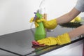 Close up shot of female hands holding bottle spray and rag for cleaning the stove Royalty Free Stock Photo