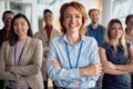 Close-up shot of female manager and her young team posing for a photo in the company building hallway. Business, people, company Royalty Free Stock Photo