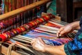 Close up shot of females hands weaving traditional Andean colorful clothes.