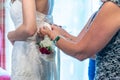 Close up shot of females helping zip a wedding dress of a bride