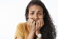 Close-up shot of freaked-out upset crying african american woman being scared and terrified trembling from fear biting Royalty Free Stock Photo