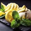 Close-up shot of a fresh creamy and citrus lemon ice cream decorated with mint and served on a stone slate over a black background Royalty Free Stock Photo