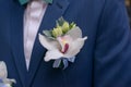 Orchid boutonniere pinned on a groom or male guest jacket Royalty Free Stock Photo