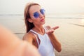 Close up shot of good looking female tourist enjoys free time outdoor near ocean beach, looks at camera during leisure Royalty Free Stock Photo