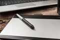 Close-up shot of graphics tablet with stylus on the background of a laptop. Essential tools for graphic designer. Professional Royalty Free Stock Photo