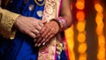 close up shot of groom and bride& x27;s hands in which they are wearing engagement rings with bookeh background of lighting