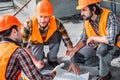 close-up shot of group of confident builders having conversation about