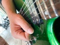 Close up shot of guitarist hands playing sparkle green guitar with focus on hands Royalty Free Stock Photo