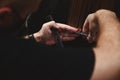 Close-up shot of hairdresser combing and cutting hair of client in beauty parlor. Beauty industry Royalty Free Stock Photo