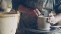 Close-up shot of half-finished ceramic vase spinning on potters& x27;s wheel and hands molding clay with professional Royalty Free Stock Photo