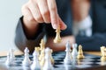 Close up shot hand of business woman moving golden chess to defeat a silver king chess on white and black chess board for Royalty Free Stock Photo