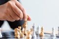 Close up shot hand of business woman moving golden chess to defeat a silver king chess on white and black chess board for Royalty Free Stock Photo