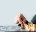 Close up shot hand of business woman moving golden chess to defeat a silver king chess on white and black chess board for Royalty Free Stock Photo